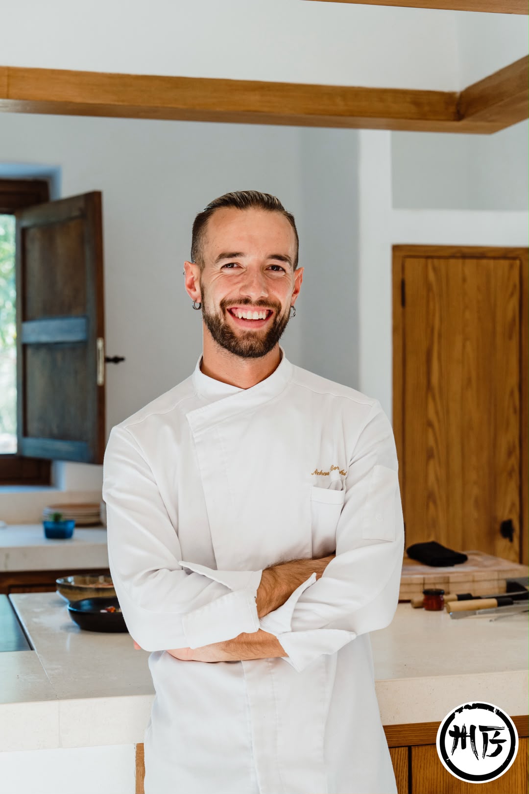 Michael Bernocchi sonriendo en la cocina, con chaquetilla blanca