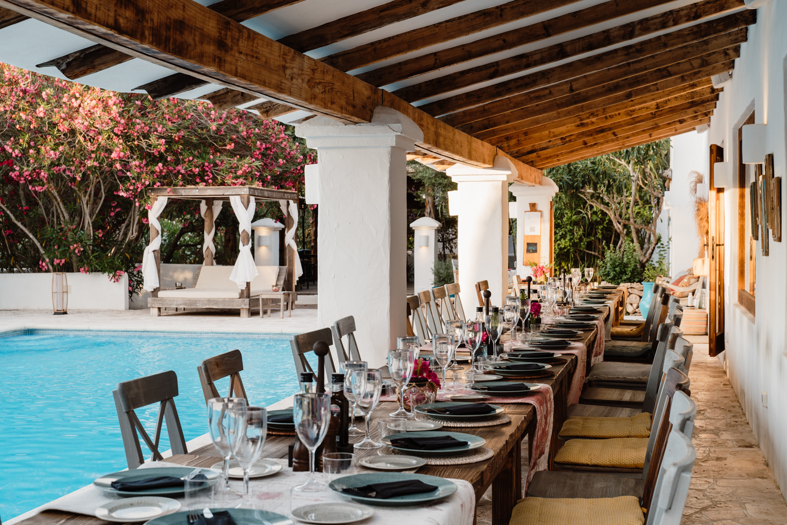 Mesa preparada para una celebración privada en la terraza de una villa junto a la piscina